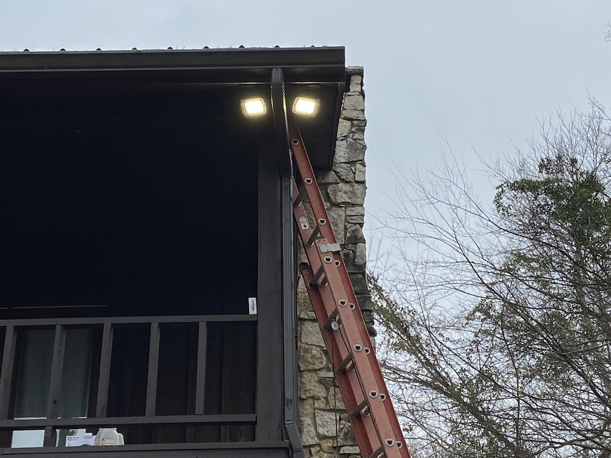 Exterior flood lighting installed on a stone-faced home